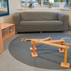 Bild einer Murmelbahn auf einem Teppich, im Hintergrund steht eine Couch.